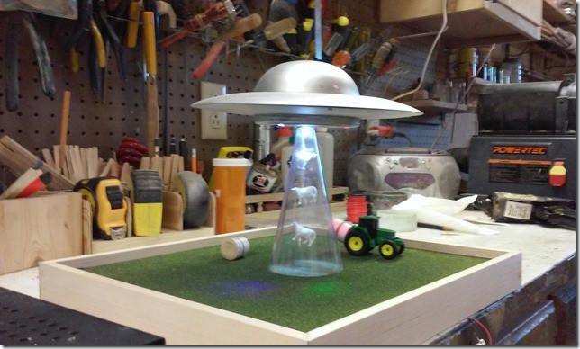 A model of a spaceship sucking up cows. A model of a spaceship sucking up cows.
