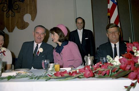 A photo of Jackie Kennedy talking to Lyndon Johnson at a banquet. A photo of Jackie Kennedy talking to Lyndon Johnson at a banquet.